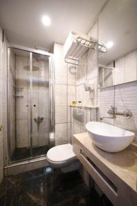 a bathroom with a toilet and a sink and a shower at Park Star Hotel Taksim in Istanbul