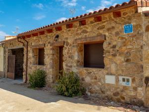 a stone building with two windows and a garage at Casa Turistica Rivera Del Zurguen in Morille