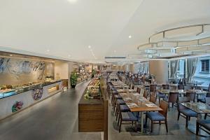 uma sala de jantar com mesas e cadeiras em um restaurante em The Kowloon Hotel em Hong Kong