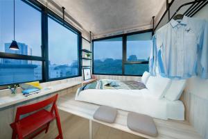 新加坡lyf Funan Singapore的一间卧室配有一张床、一张书桌和一个窗户。 更多37张照片