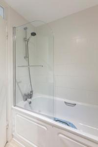 倫敦的住宿－泰特現代河景公寓，浴室设有带玻璃淋浴的浴缸