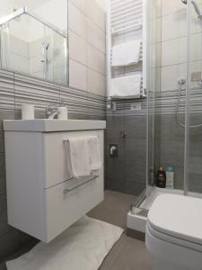 a bathroom with a sink and a toilet and a shower at Assago Forum Apartment in Assago