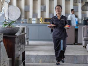 a woman in an office holding a plate of food at Selong Selo Resort and Residences in Selong Belanak +37 photos