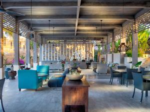 a lobby with blue chairs and tables in a building at Selong Selo Resort and Residences in Selong Belanak