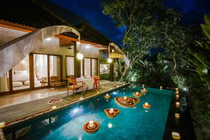 a swimming pool in the middle of a villa at Purana Suite Ubud in Ubud