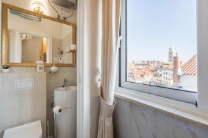 uma casa de banho com uma janela, um WC e um lavatório. em Olivia Luxury Rooms em Split