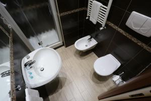 La salle de bains est pourvue d'un lavabo blanc et de toilettes. dans l'établissement Hotel Europa, à Foggia