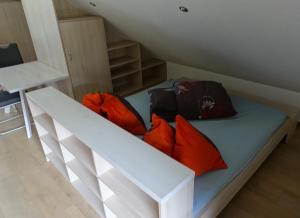 Bett mit orangefarbenen Kissen auf einem Zimmer in der Unterkunft Urlauben im Grünen in Fuschl am See