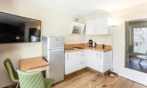 małą kuchnię z białą lodówką i stołem w obiekcie Kitzbühel City 1 w mieście Kitzbühel