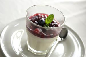 ein Glas Dessert auf einem Teller mit einem Löffel in der Unterkunft Kalinowe Pola Golf Village in Niesulice