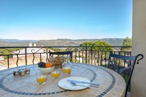 - une table avec des verres de jus d'orange et un bol de fruits dans l'établissement Les Appartements et Maisons du Domaine de Saint Endréol Golf & Spa Resort, à La Motte