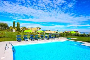 einen Pool mit Liegestühlen und Sonnenschirmen in der Unterkunft Relais Rosa Dei Venti -Ciao Vacanze- in Moniga