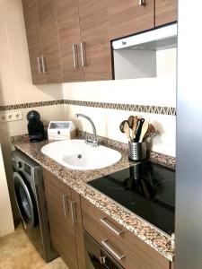 a kitchen with a sink and a washing machine at SKI & NATURE JAVALAMBRE in Camarena de la Sierra +36 photos