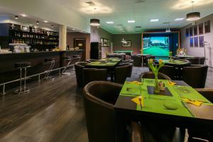 a restaurant with tables and chairs and a bar at Kalinowe Pola Golf Village in Niesulice