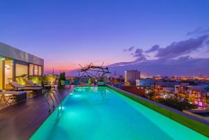 a swimming pool on the roof of a building at night at Prana Boutique Hotel and Apartments in Danang