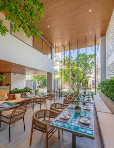 a restaurant with tables and chairs and windows at Prana Boutique Hotel and Apartments in Da Nang