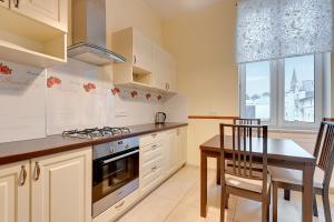 a kitchen with a table and a stove top oven at Happy Stay Apartments Sopot Bema in Sopot