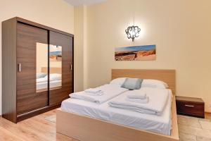 Un dormitorio con una cama con sábanas blancas y un espejo. en Happy Stay Apartments Sopot Bema, en Sopot