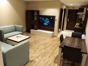 a living room with a couch and a tv and a table at Royal Golden House in Dammam