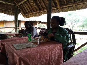 Un par de personas sentadas en una mesa comiendo comida. en Mailua Retreat en Mailua