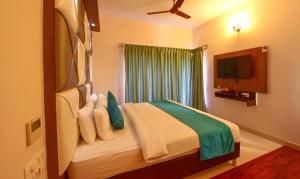 a bedroom with a bed with a window and a tv at Hotel Sanman Gardenia in Bangalore