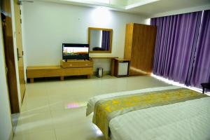 Habitación de hotel con cama y TV en Annex Suites Bogra - CityCentre en Bogra