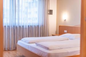 - 2 lits dans une chambre d'hôtel avec fenêtre dans l'établissement Angerhof, à Caldaro