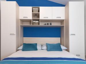 een slaapkamer met een blauw hoofdeinde en witte kasten bij Apartments Marli in Split