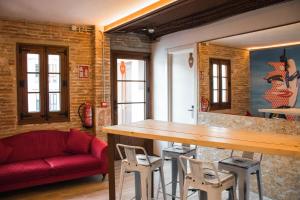 sala de estar con mesa de madera y sofá rojo en Àmfores Boutique Guest House, en Barcelona