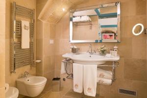 a bathroom with a sink and a toilet and a mirror at Hotel Don Ferrante in Monopoli