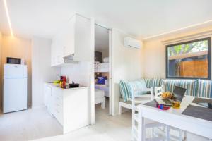 a small kitchen and living room with a white refrigerator at Tamarit Beach Resort in Tamarit