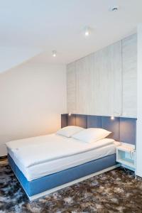 1 dormitorio con 1 cama grande y cabecero grande en Hotel Jantar Wellness & Spa en Ustka
