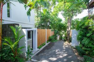 a driveway leading to a house with a fence at Peach Blossom Resort & Pool Villa - SHA Plus in Kata Beach