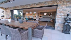 a dining room and living room with a brick wall at Les Geais - Marevalande in Sainte-Maxime