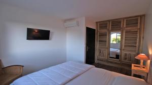a bedroom with a white bed and a window at Les Geais - Marevalande in Sainte-Maxime