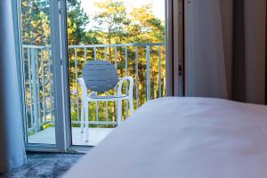 Hotel Jantar Wellness & Spa في أوستكا: غرفة نوم مع كرسي على شرفة