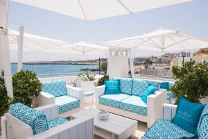 a balcony with blue and white chairs and a table at Hotel Don Ferrante in Monopoli