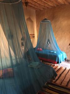 a bedroom with a bed with a mosquito net at Kasbah Luna del Sur in Merzane