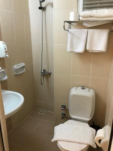 a bathroom with a toilet and a sink and towels at Hotel Status in Fethiye