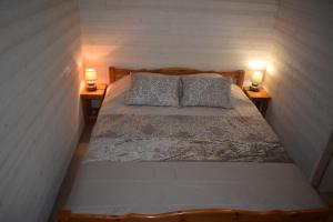 a bedroom with a bed with two lamps on both sides at Chez Augustin in Lacanau-Océan