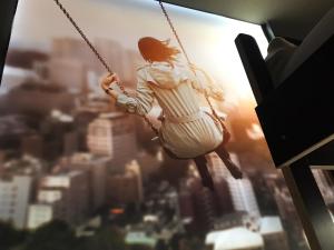 a woman sitting on a swing in a city at BoxHotel Hannover in Hannover