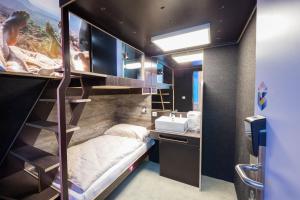 1 dormitorio con litera y lavamanos en BoxHotel Hannover en Hannover