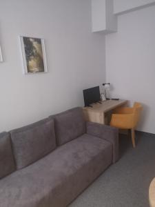 a living room with a couch and a desk with a computer at Hotelik Elka-Sen in Szczecin