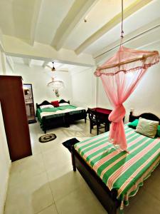 a living room with two beds and a room with a bed istg at Casalanka Hotel in Hikkaduwa