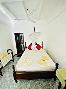 a bedroom with a bed with white sheets and red pillows at Casalanka Hotel in Hikkaduwa