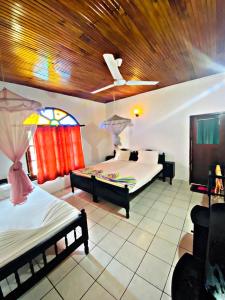 a bedroom with two beds and a wooden ceiling at Casalanka Hotel in Hikkaduwa