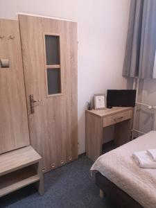 a bedroom with a bed and a door and a desk at Hotelik Elka-Sen in Szczecin