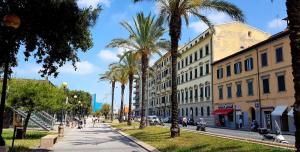 a city street with palm trees and buildings at ALmare - Sea Front in Livorno