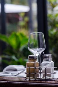 una mesa con una copa de vino y dos jarras de vidrio en Hôtel Restaurant La Ribaudière, en Antananarivo