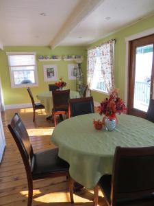 a dining room with a green table and chairs at That Country Place B&B in Hanna